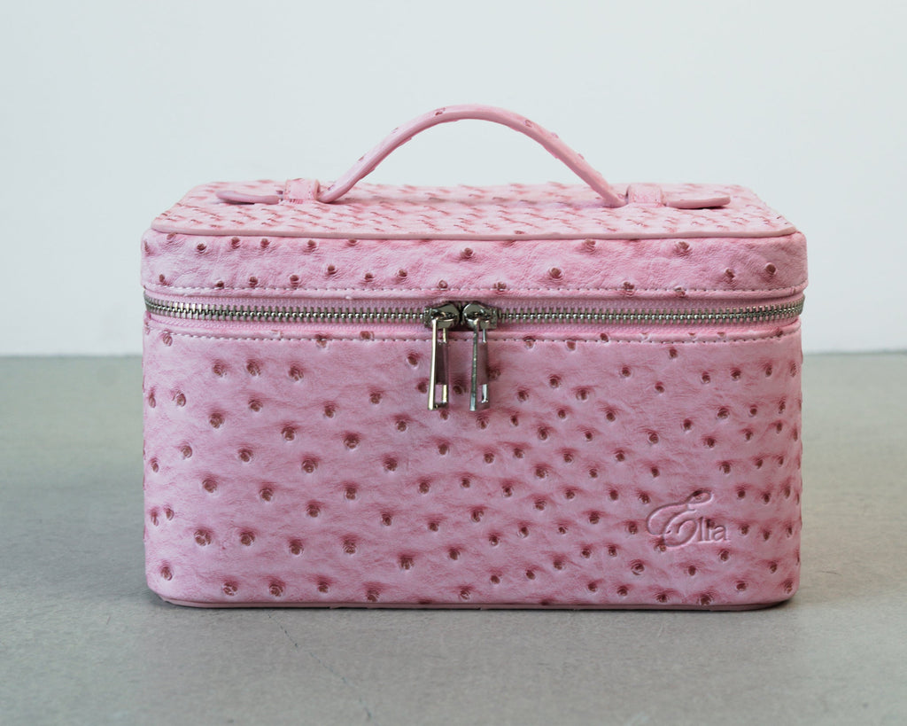 Pink textured makeup bag with a visible brand logo on a light gray background